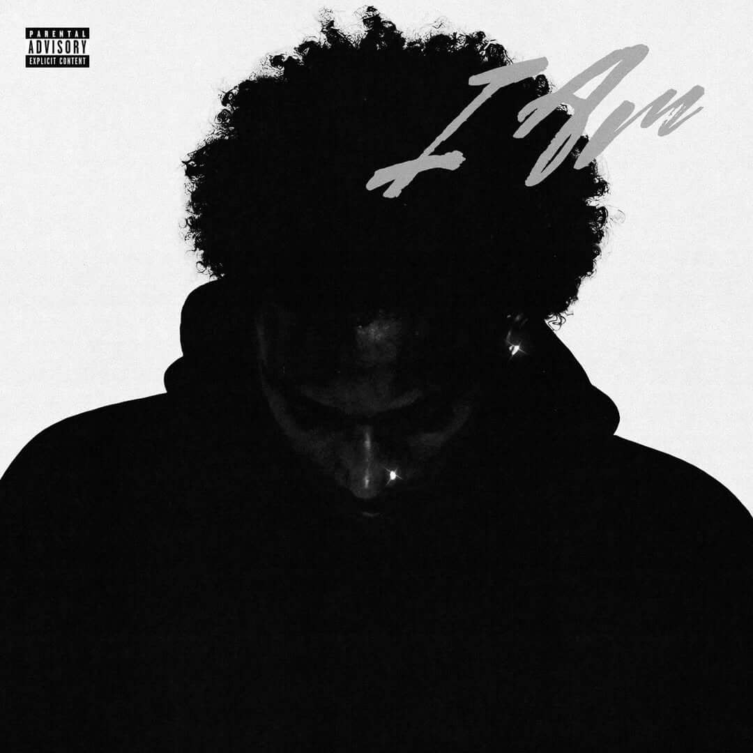 The cover art for RJAE's third album 'I AM,' featuring a silhouette of RJAE against a gray background with the handwritten title in the top right corner.